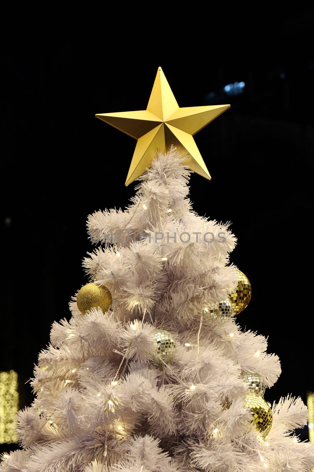 Golden Star and ball decoration on white Christmas tree background night (selective focus) by cgdeaw