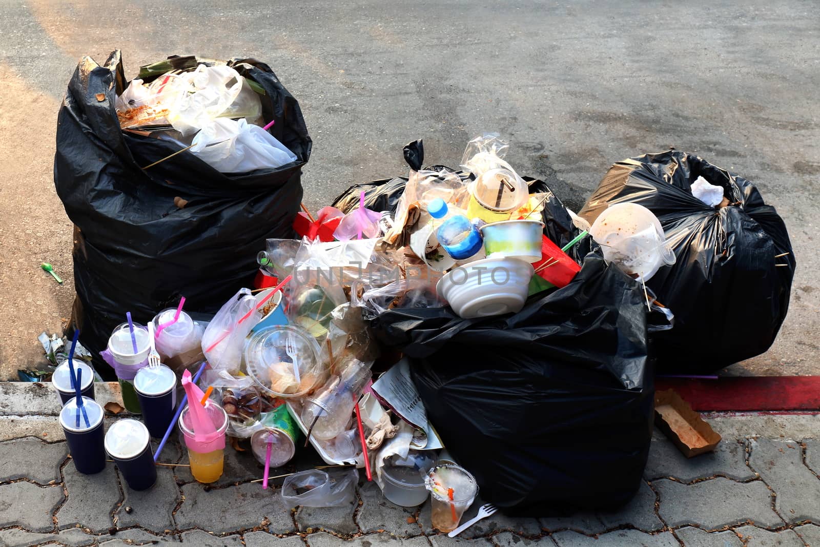 Pile of Garbage plastic black and trash bag waste many on the footpath, pollution trash, Plastic Waste and Bag Foam tray Garbage many on floor, Waste plastic