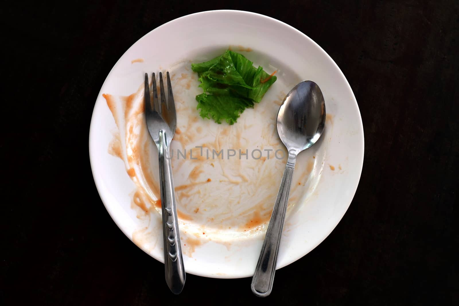 plate empty trash food and Leaves of green vegetables on a plate of rice, plate fork and spoon