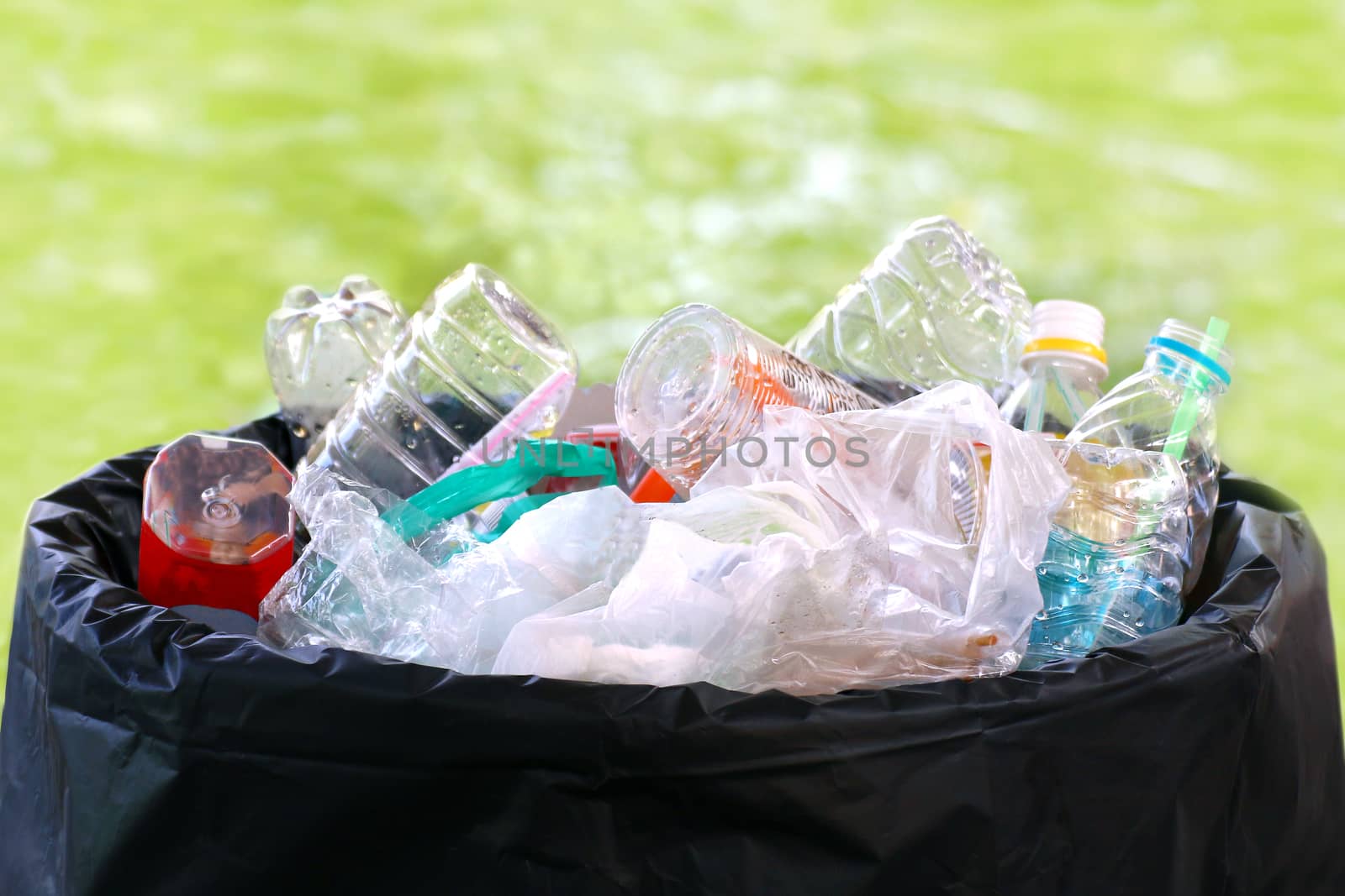 Waste heap plastic on bin, Waste Garbage trash plastic full of trash bin, Plastic bag waste Lots of junk on bokeh green background, Garbage many close-up