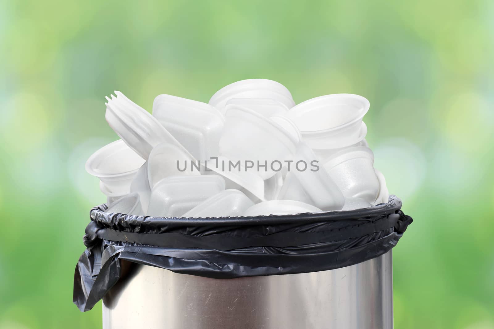 bin of waste foam tray on nature green background, waste garbage foam food tray white many pile on plastic recycle and bin stainless