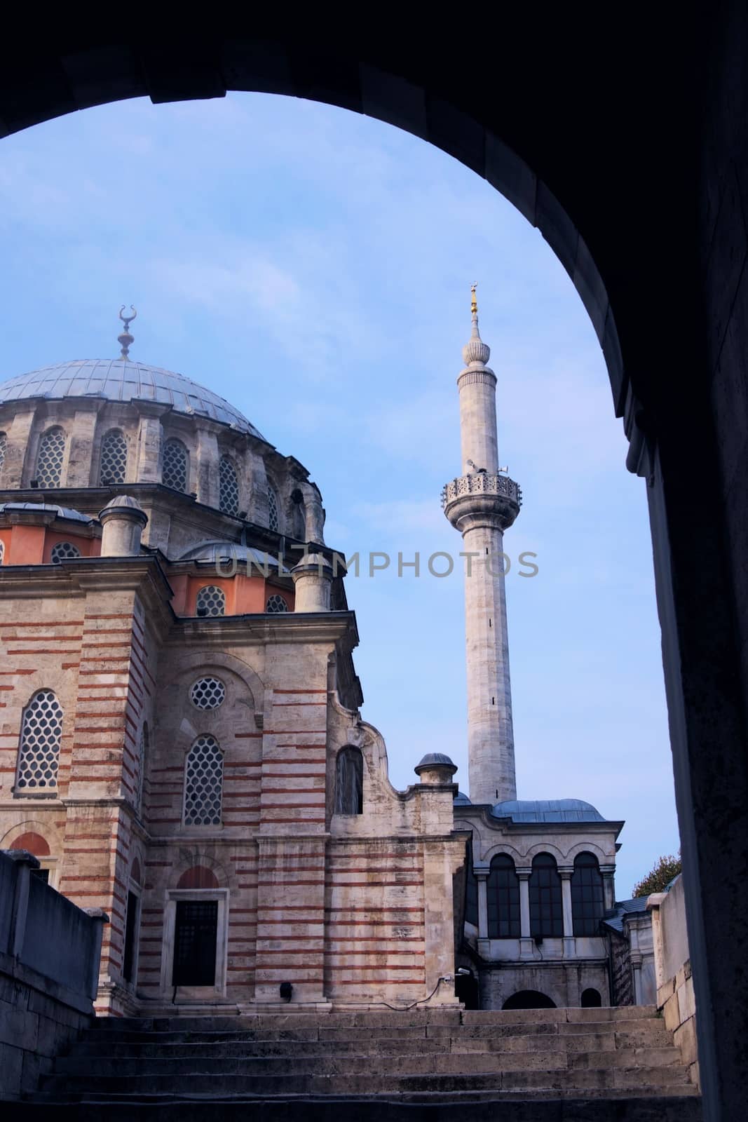 Old mosque in Istanbul, Turkey. Exterior view of the main dome and minarets, taken from the entrance archway. by hernan_hyper