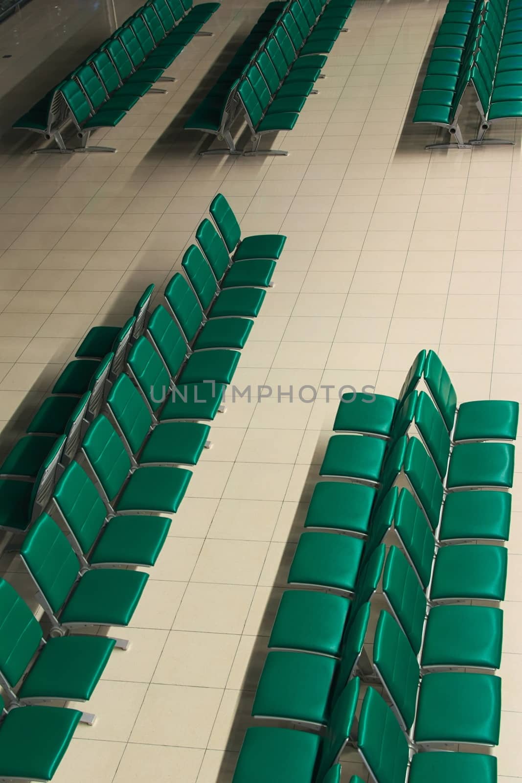 Green empty seats at an airport waiting area. High angle view. by hernan_hyper