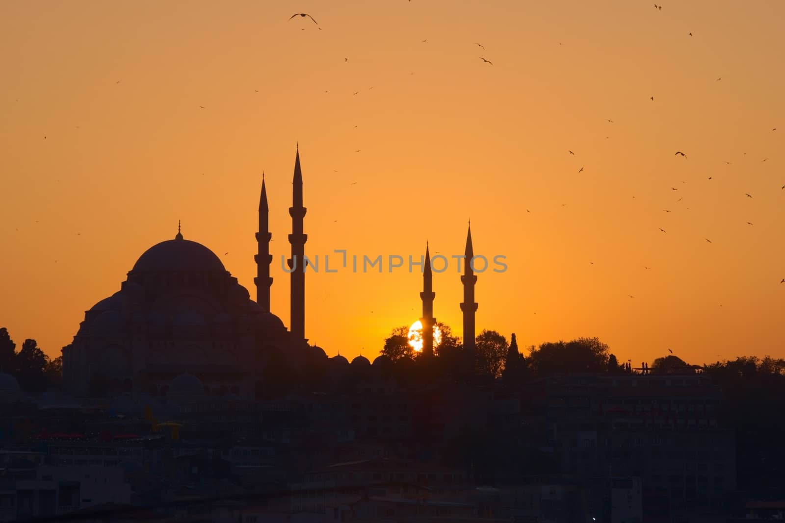 Hagia Sophia, the most important tourist attraction of Istanbul, Turkey, silhouetted against the ochre sunset sky.