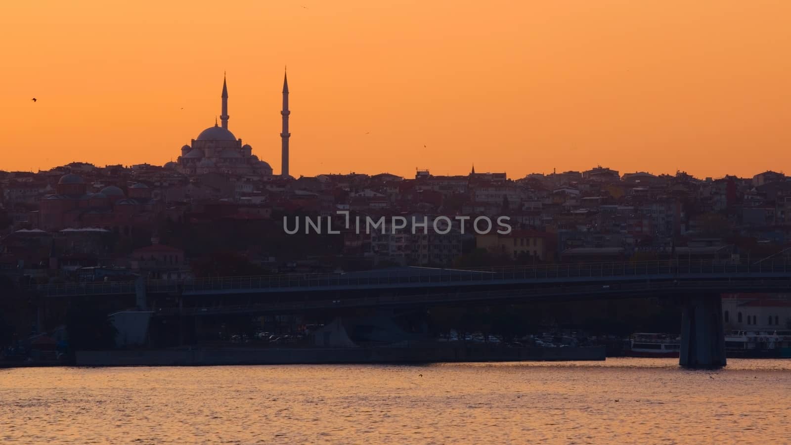 Hagia Sophia, the most important tourist attraction of Istanbul, Turkey, silhouetted against the ochre sunset sky from across the Bosphorus. by hernan_hyper