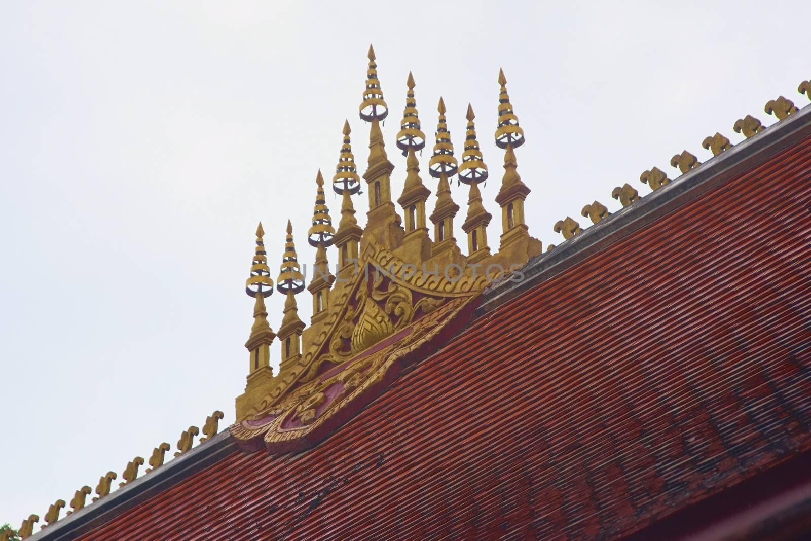 Gilded ornament representing stupas on the rooftop of a Buddhist temple in Luang Prabang, Laos.