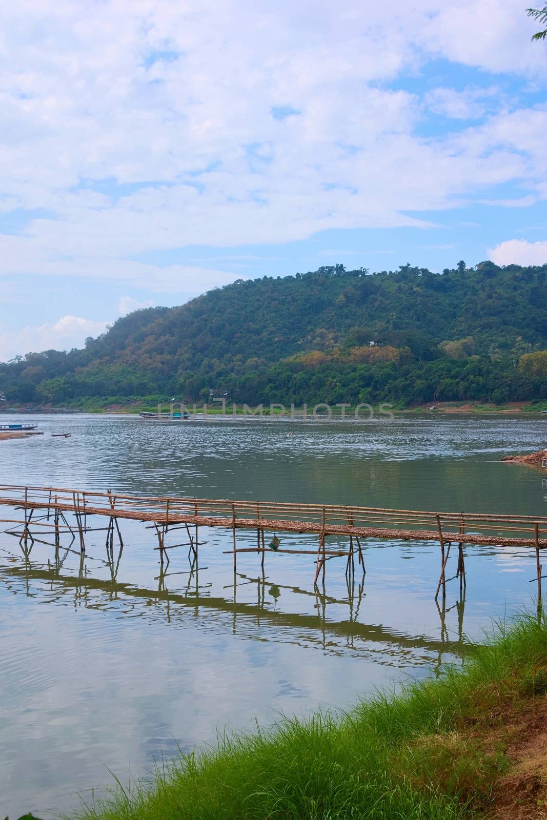 Bamboo bridge over Nam Khan river, in the confluence with Mekong River in Luang, Prabang, Laos. by hernan_hyper