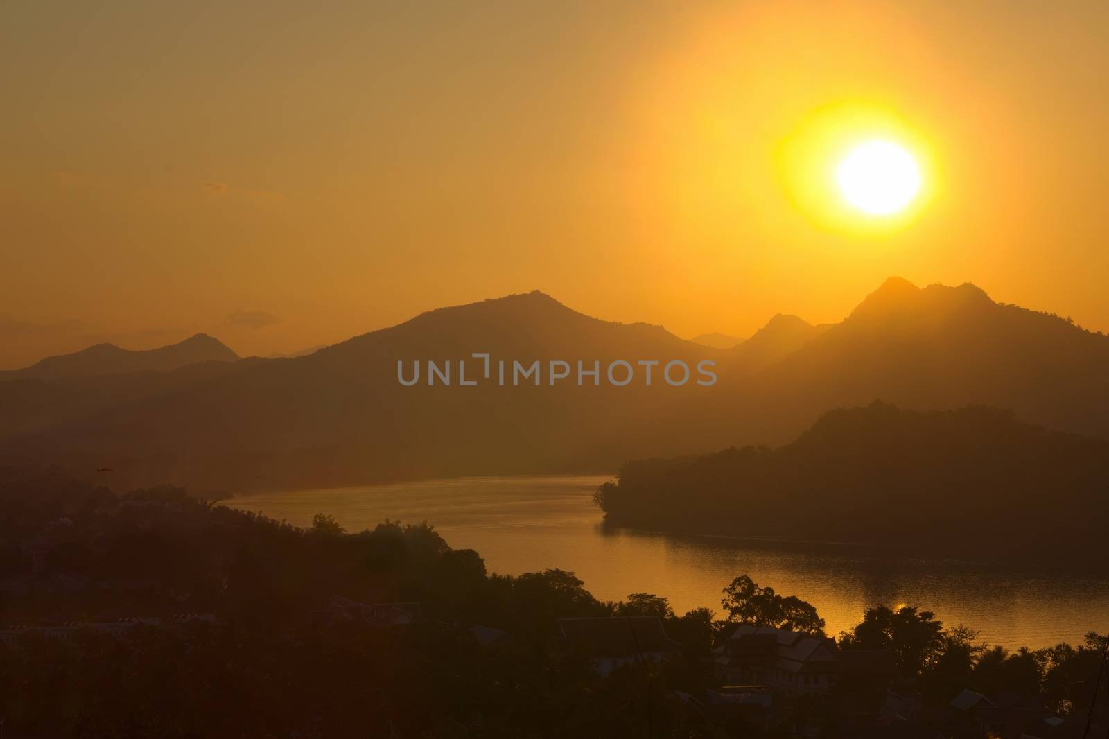 Sunset over hazy mountains by the Mekong river. View from Mount Phou Si, in Luang Prabang, Laos.