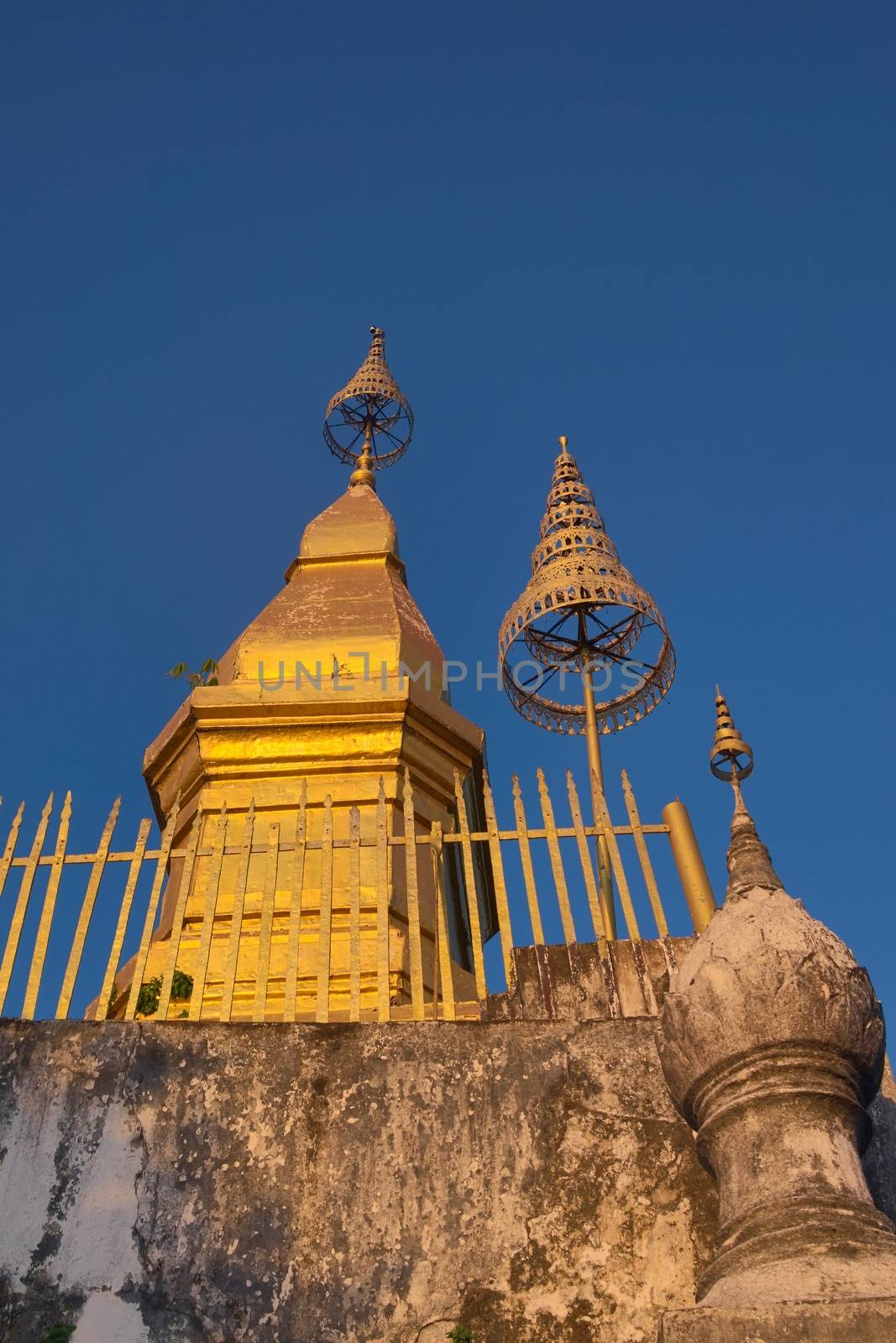 Golden stupa on the summit of Mount Phou Si, located in Luang Prabang, Laos, at sunset. by hernan_hyper