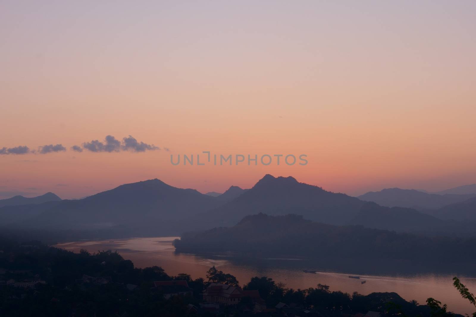 Twilight colors over hazy mountains by the Mekong river. View from Mount Phou Si, in Luang Prabang, Laos. by hernan_hyper