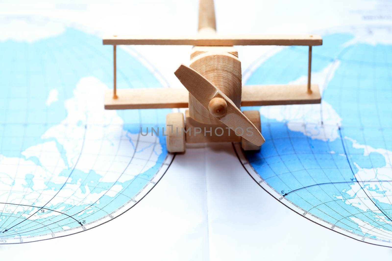 Travel concept. Small wooden airplane on map between two continent