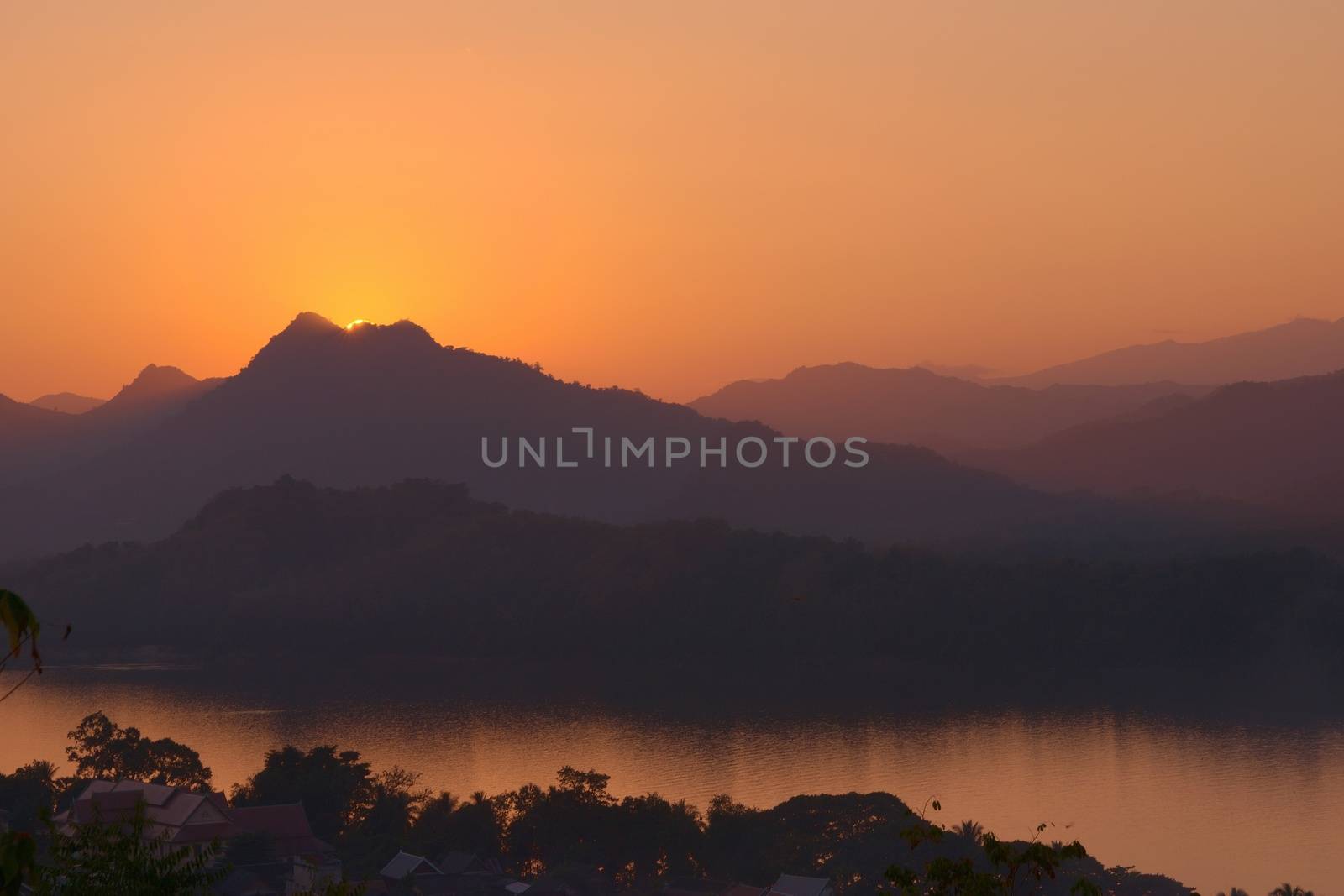 Sunset over the Mekong river and hazy mountains. View from Mount Phou Si, in Luang Prabang, Laos.