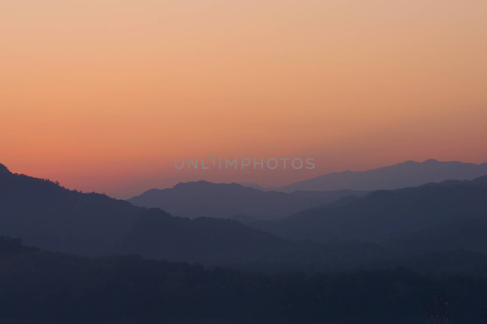 Twilight sky over hazy mountains. View from atop Mount Phou Si, in Luang Prabang, Laos. by hernan_hyper