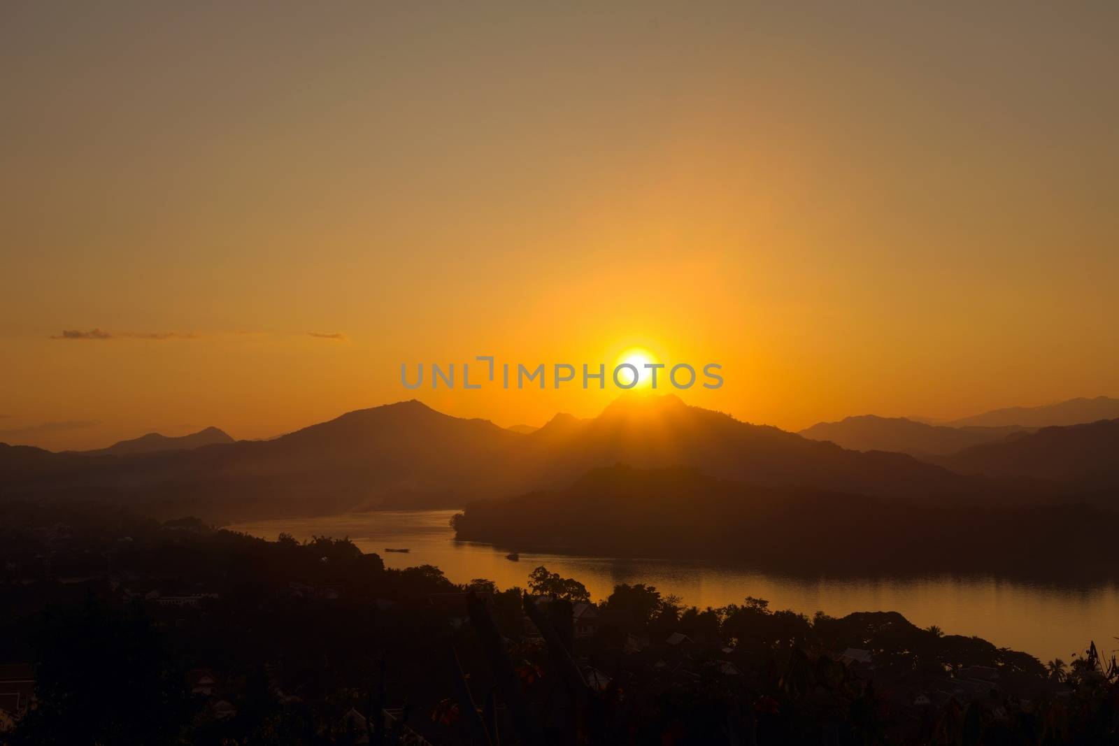 Glorious sunset over hazy mountains by the Mekong river. View from Mount Phou Si, in Luang Prabang, Laos. by hernan_hyper