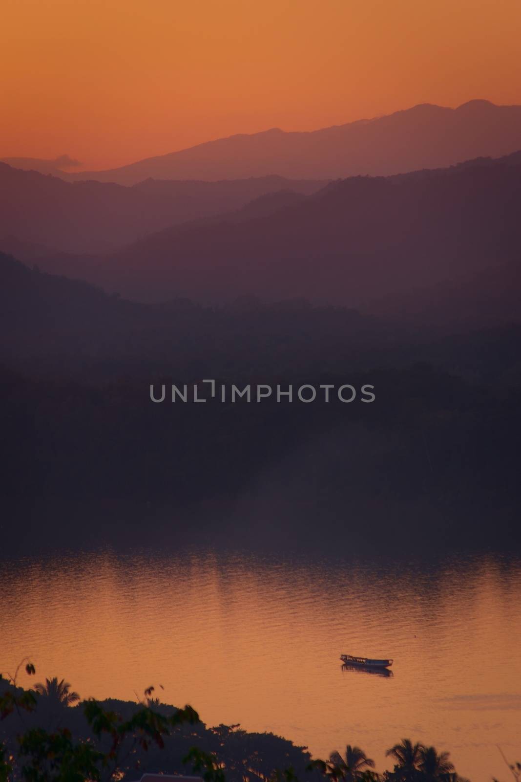 Twilight colors over hazy mountains by the Mekong river. View from Mount Phou Si, in Luang Prabang, Laos.