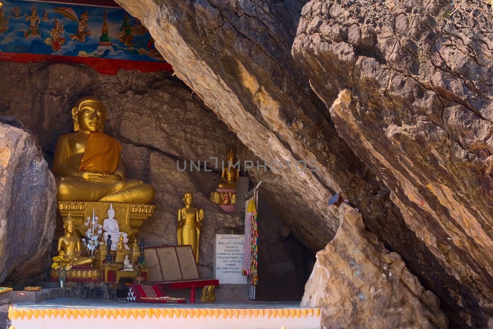 Golden statue of Buddha on a crevice of the rock at Mount Phou Si, in Luang Prabang, Laos. The entrance of the cave shrine can be seen on the right side. by hernan_hyper