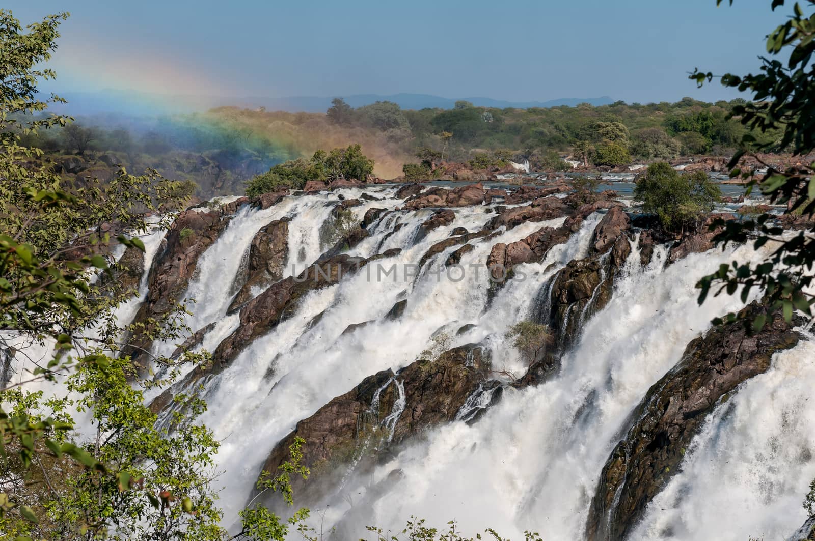 Part of the Ruacana waterfall in the Kunene River. A rainbow and dragonflies are visible