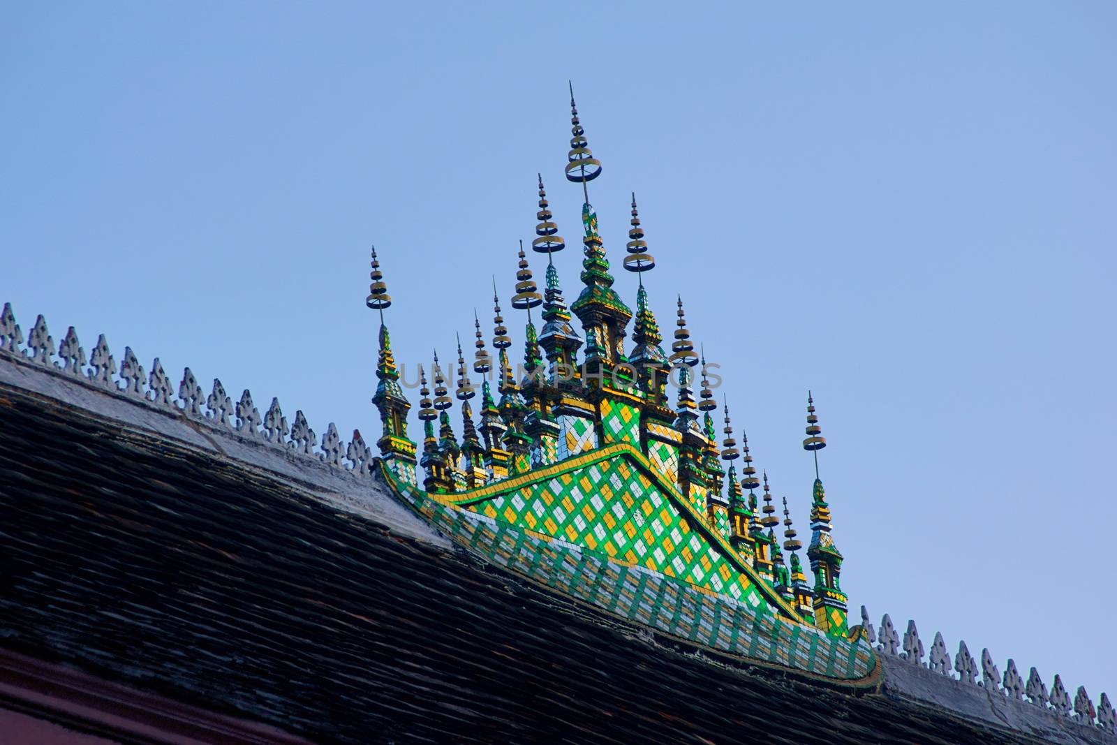 Buddhist temple of Wat Wisunarat in Luang Prabang, Laos. Architectural detail of the glass mosaic ornament on top of the rooftop.