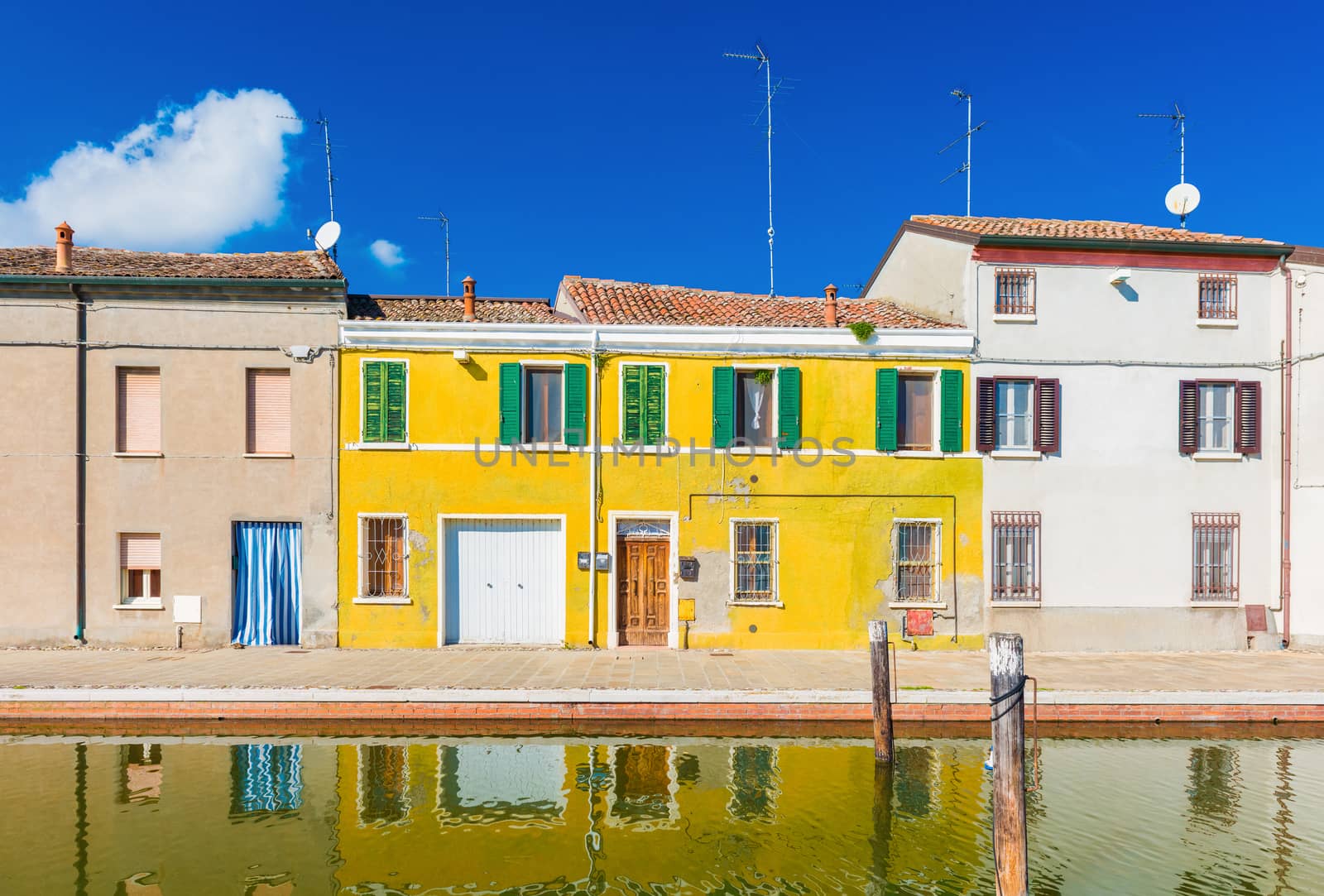 Colored houses reflected in the water. The old street in Comacchio - a small town in the province of Ferrara (Emilia Romagna), also known as "The Little Venice"