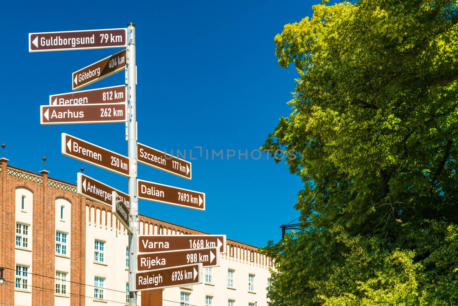 Street sign with directions pointers and distances to the different cities of the world. Rostock, Germany