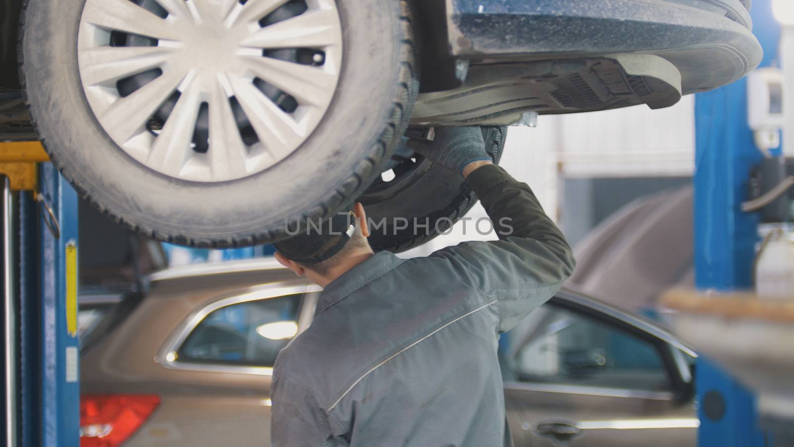 Mechanic working on a tire service on the lift in a service station, close up