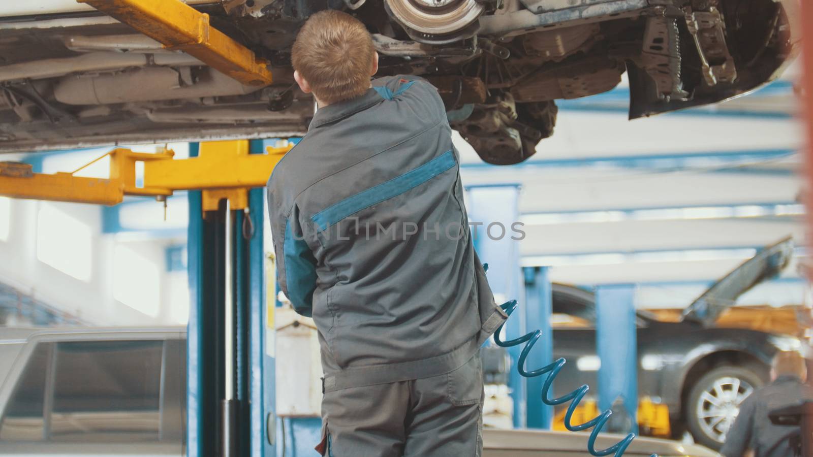Automobile service - mechanic wrapping working device under car bottom, slider