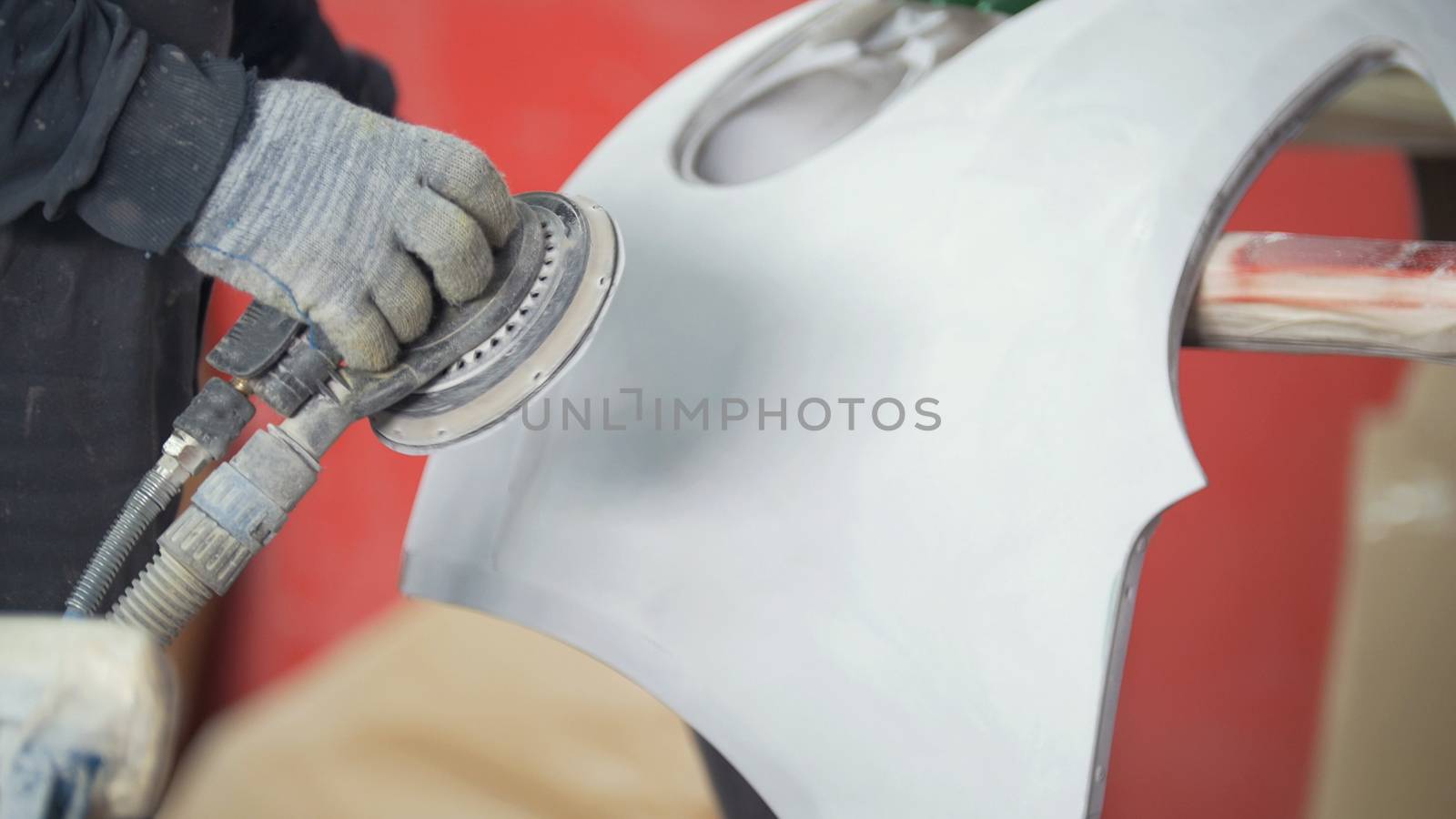 Man polishing bumper in a service station garage by Studia72