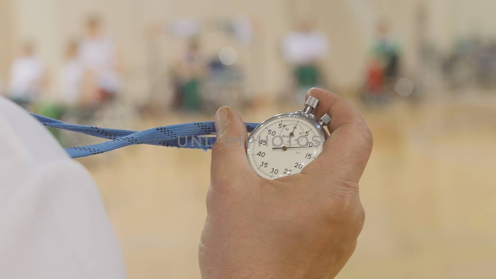 Stopwatch in hand of coach during training for wheelchair basketball, close up