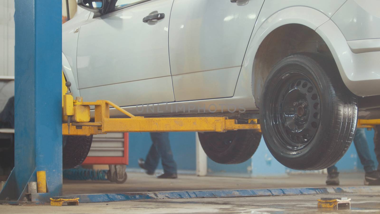 Lifted car in professional car service - the collapse of convergence - process repairing, close up