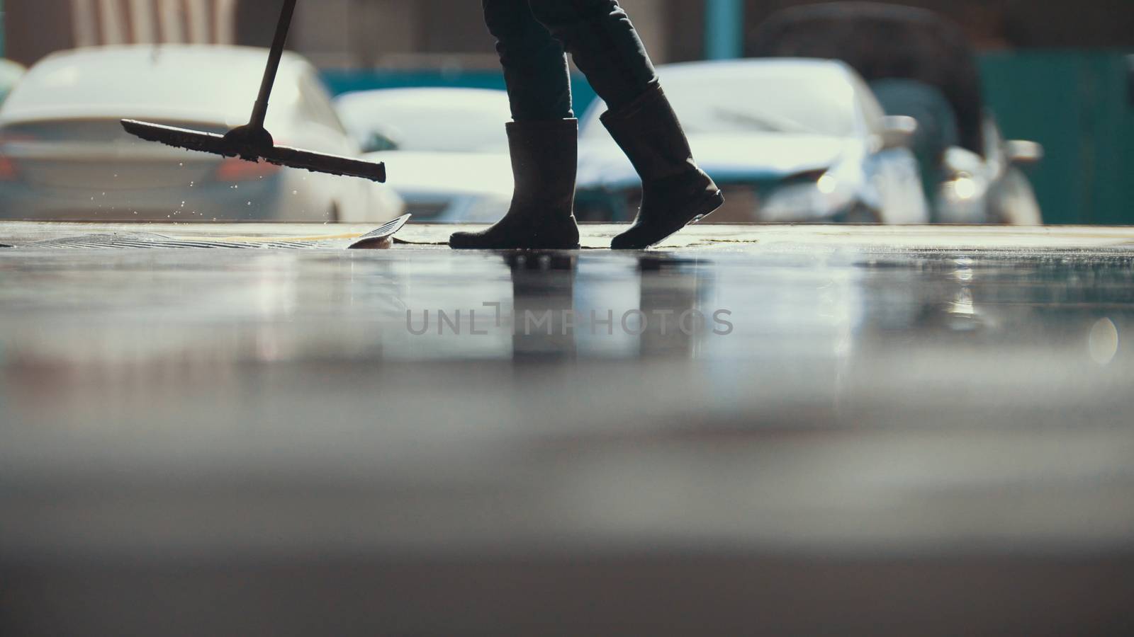 Worker remove foam and water with a MOP after car washing, close up