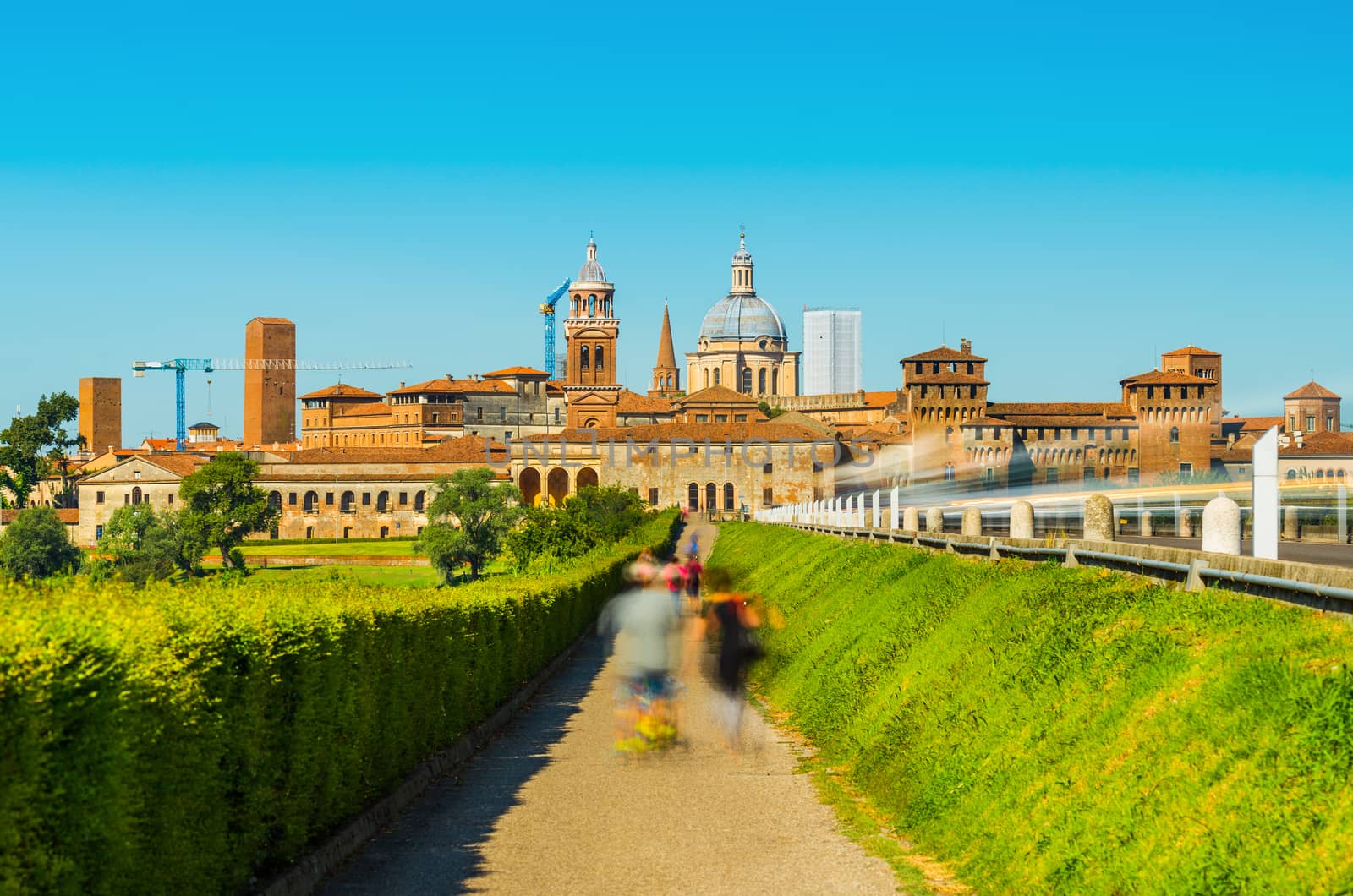 Mantova skyline, Lombardy, Italy. People with children walking towards the old city center