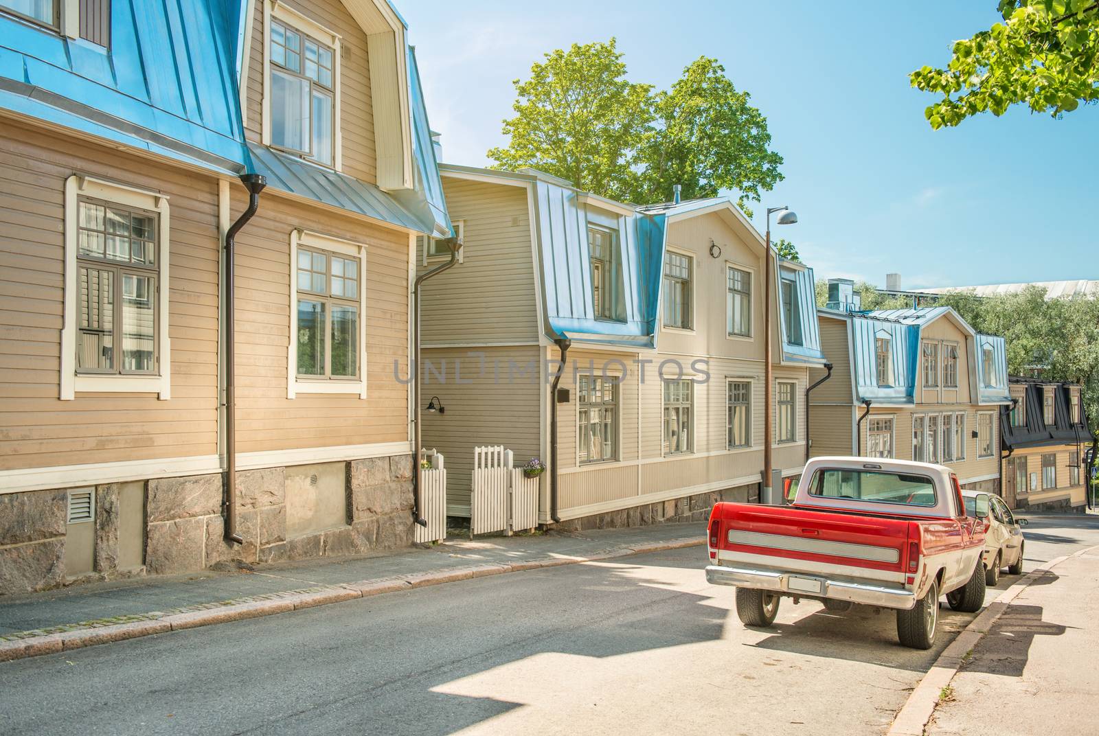 A street in Helsinki on a sunny summer day. Traditional finnish wooden houses in a quiet cozy street, Finland