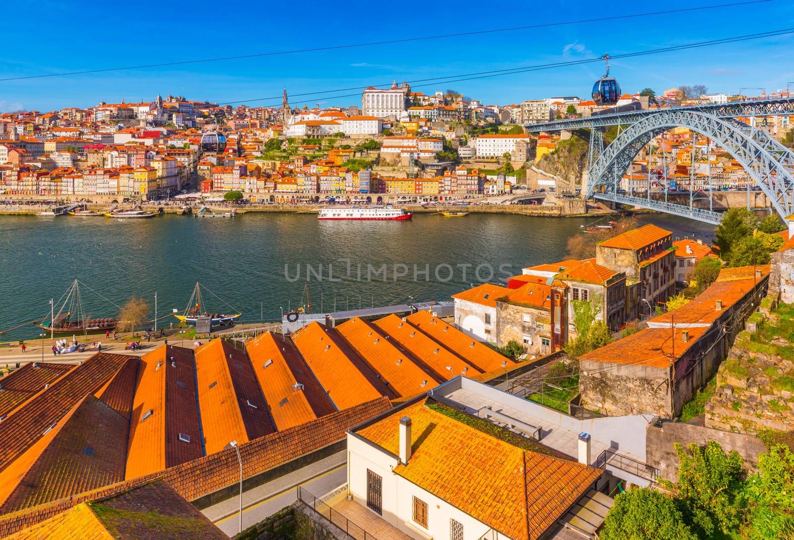Cityscape of Porto with Dom Luis I Bridge, old architecture and cable car, Portugal
