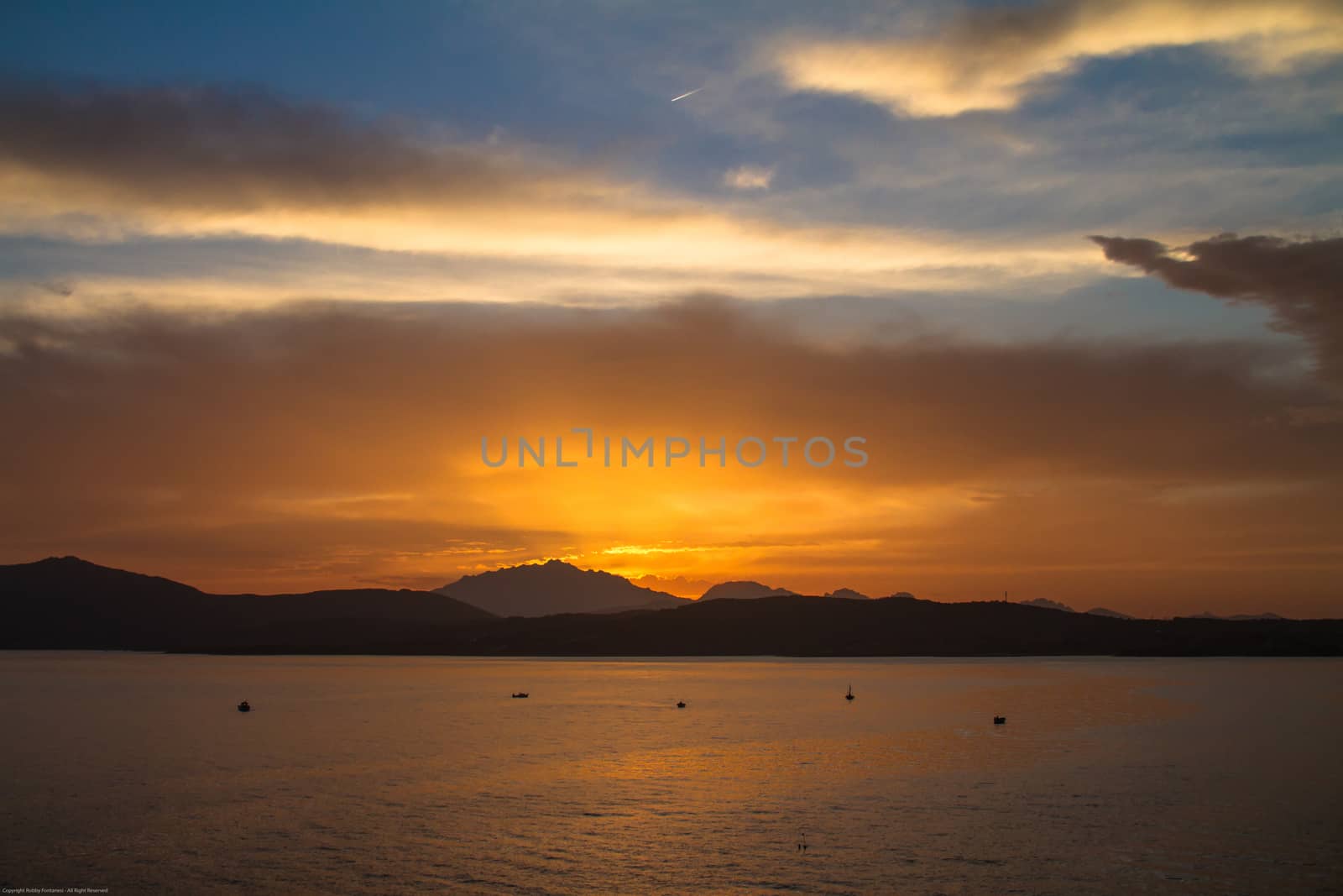 Sunrise on the Sardinian sea coast with intense orange color see by robbyfontanesi