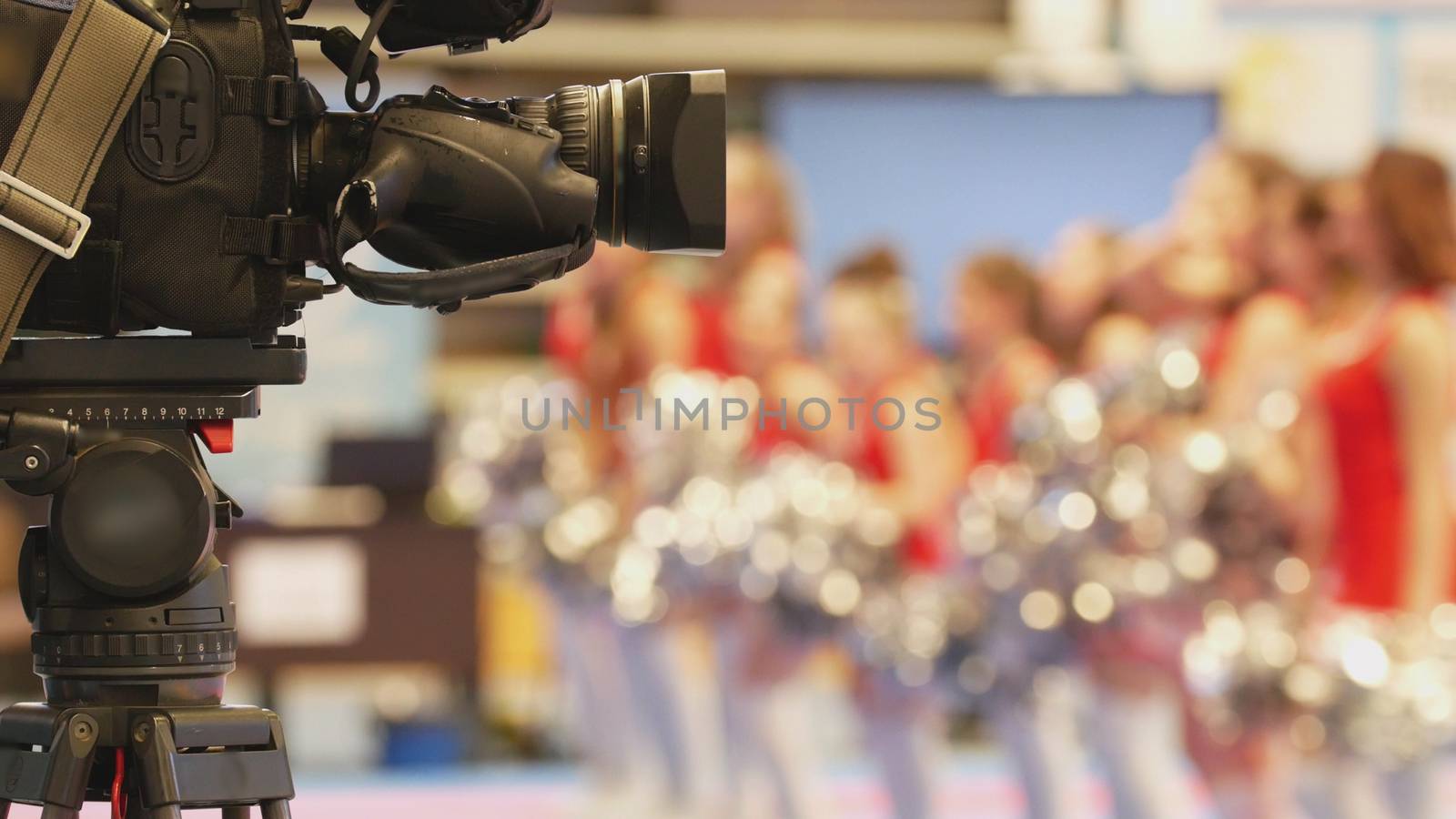 Camera in front of girls cheerleaders at sport championship, blurred