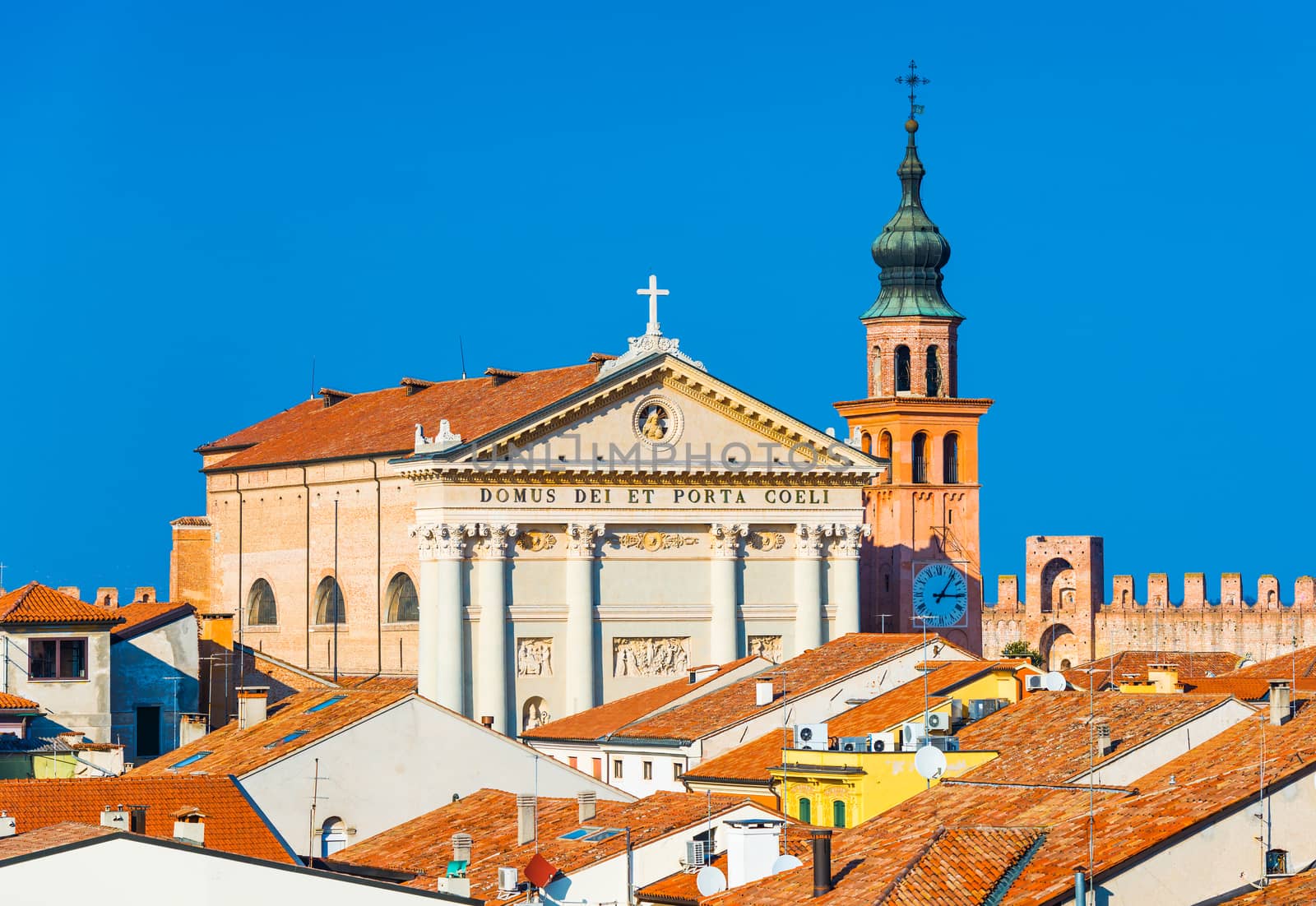 Cathedral in the walled Italian city of Cittadella, Italy. The text in Latin: The temple of the Gate and Heaven. Orange roof tiles as a part of traditional architecture style.