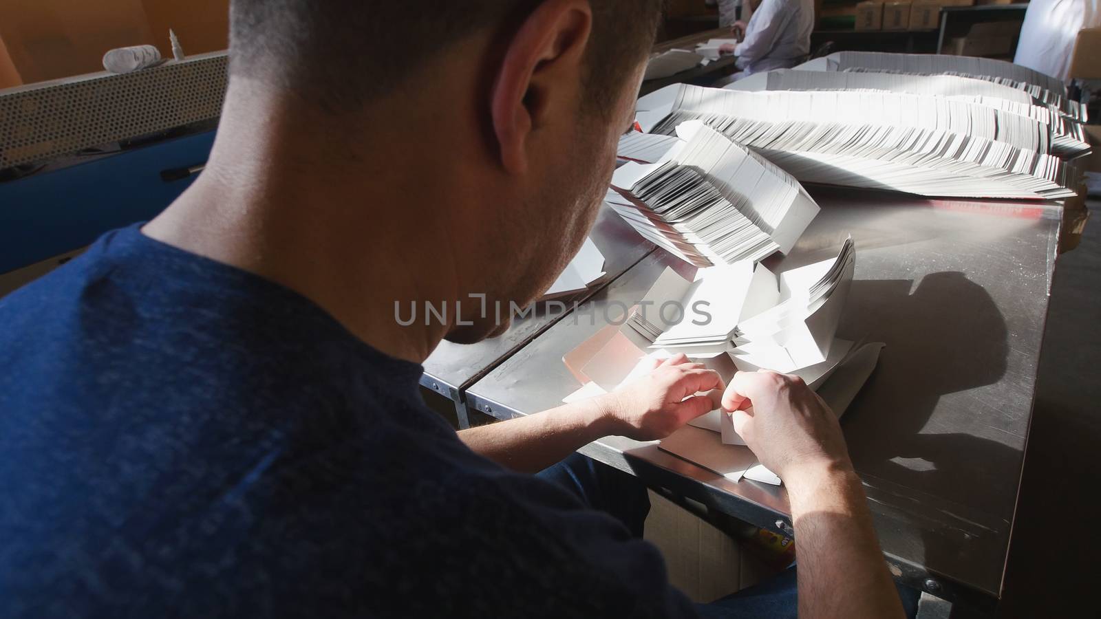 Worker making the boxes for sugar refinery on food factory, close up