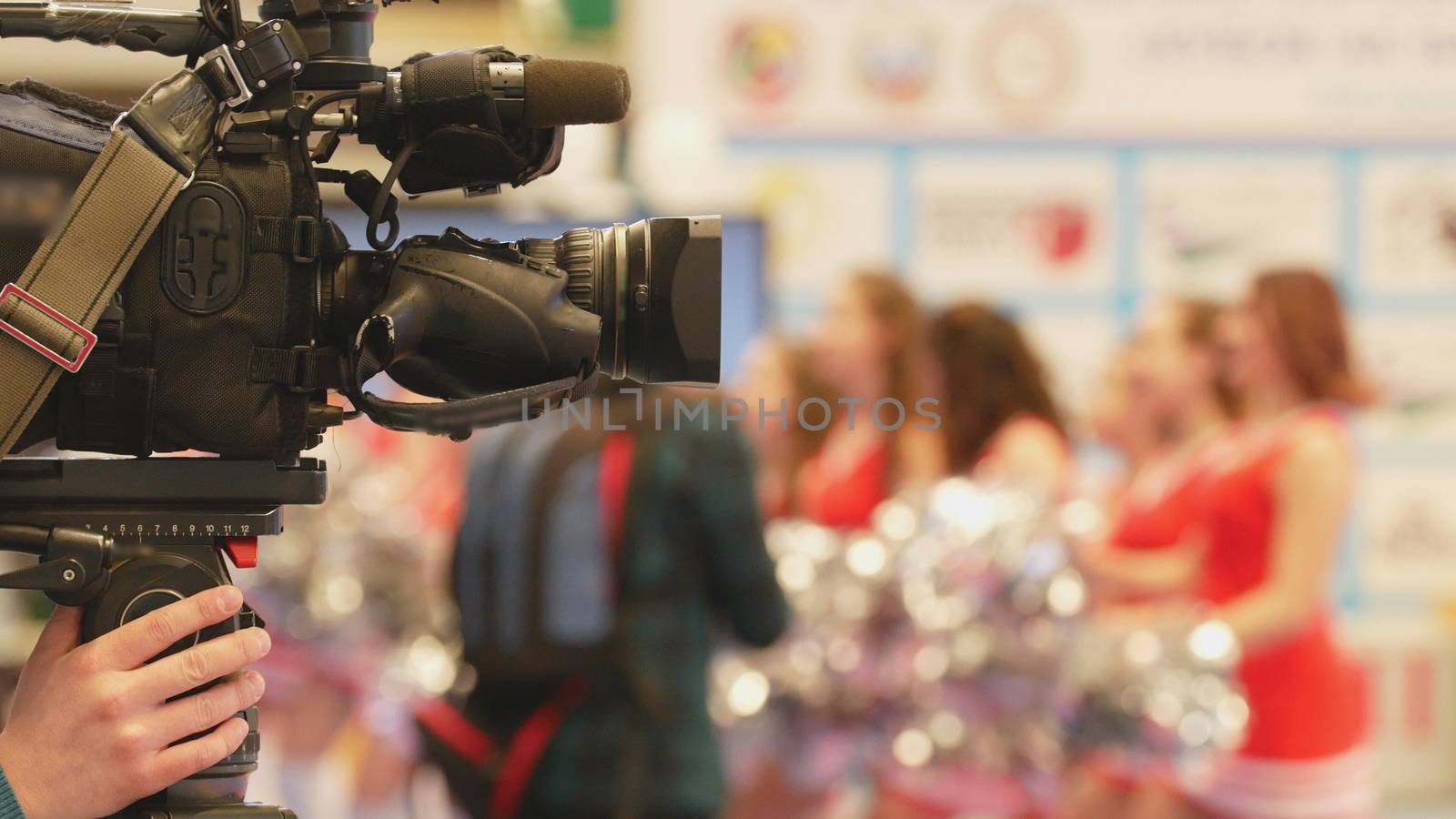 Camera in front of girls cheerleaders at the karate championship, blurred