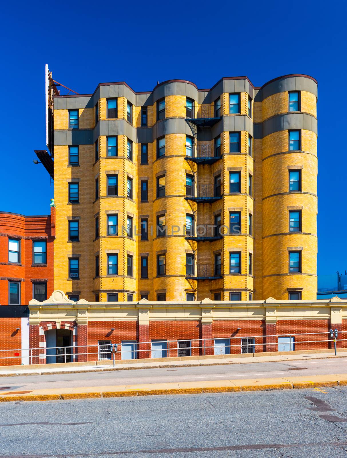 Residential building made of yellow bricks. Apartment block in the street of Boston, Massachusetts, USA. Summer day with clear blue sky.