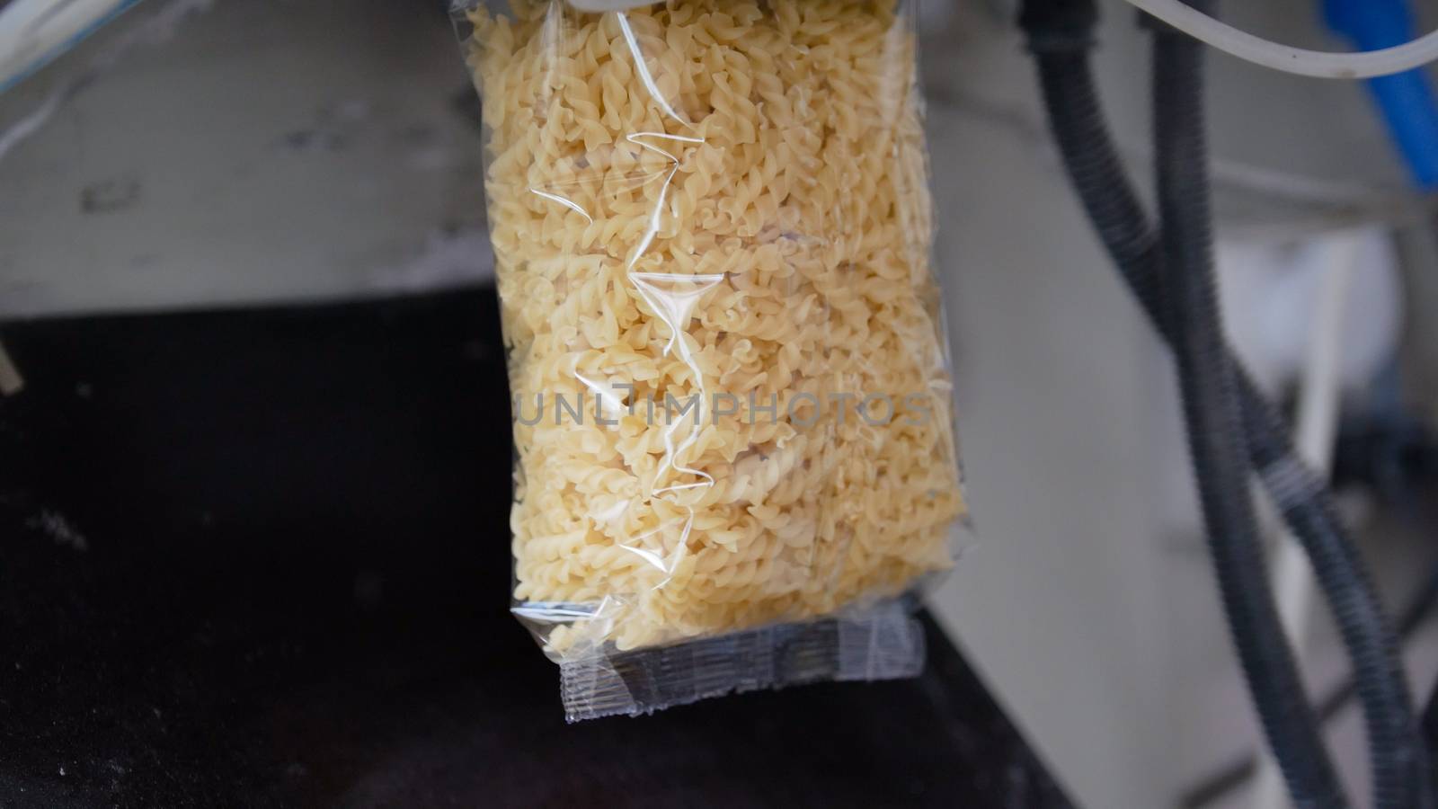 Food industry - packing of macaroni in plastic bags, telephoto