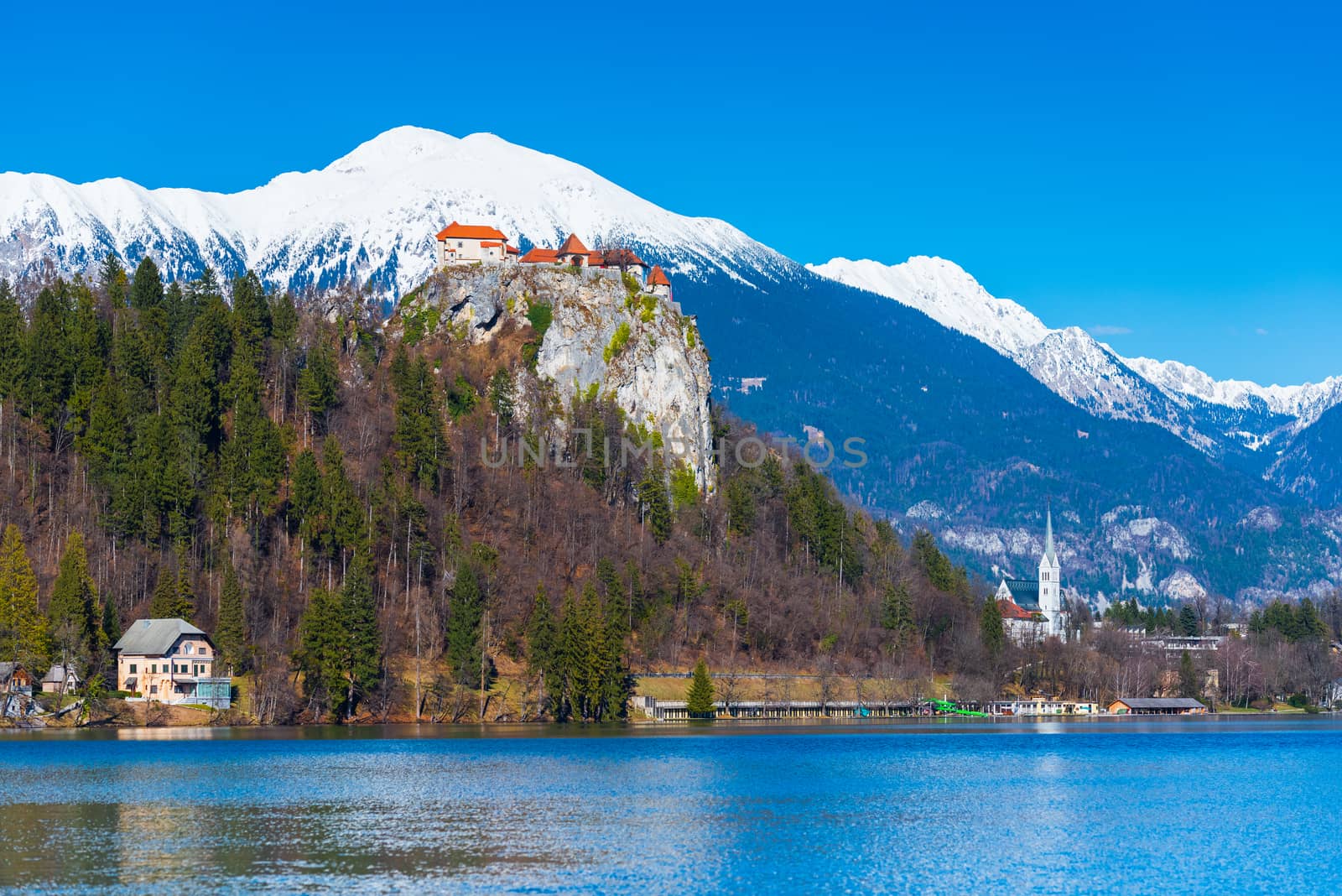 Lake Bled in Slovenia. Old medieval castle on the rock, snowy mountains and the blue sky on the background