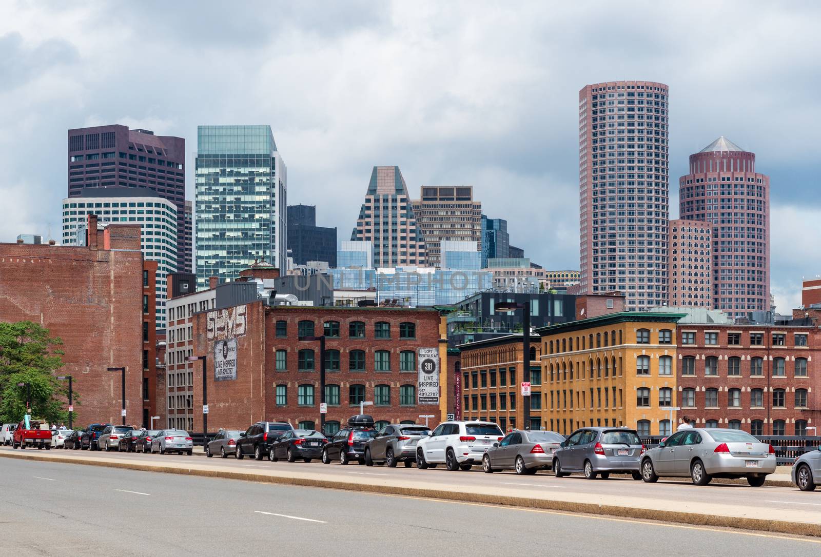 Boston - June 2016, MA, USA: Boston cityscape in a cloudy day, view on skyscrapers and historic old buildings in downtown, cars parked on the bridge above the highway