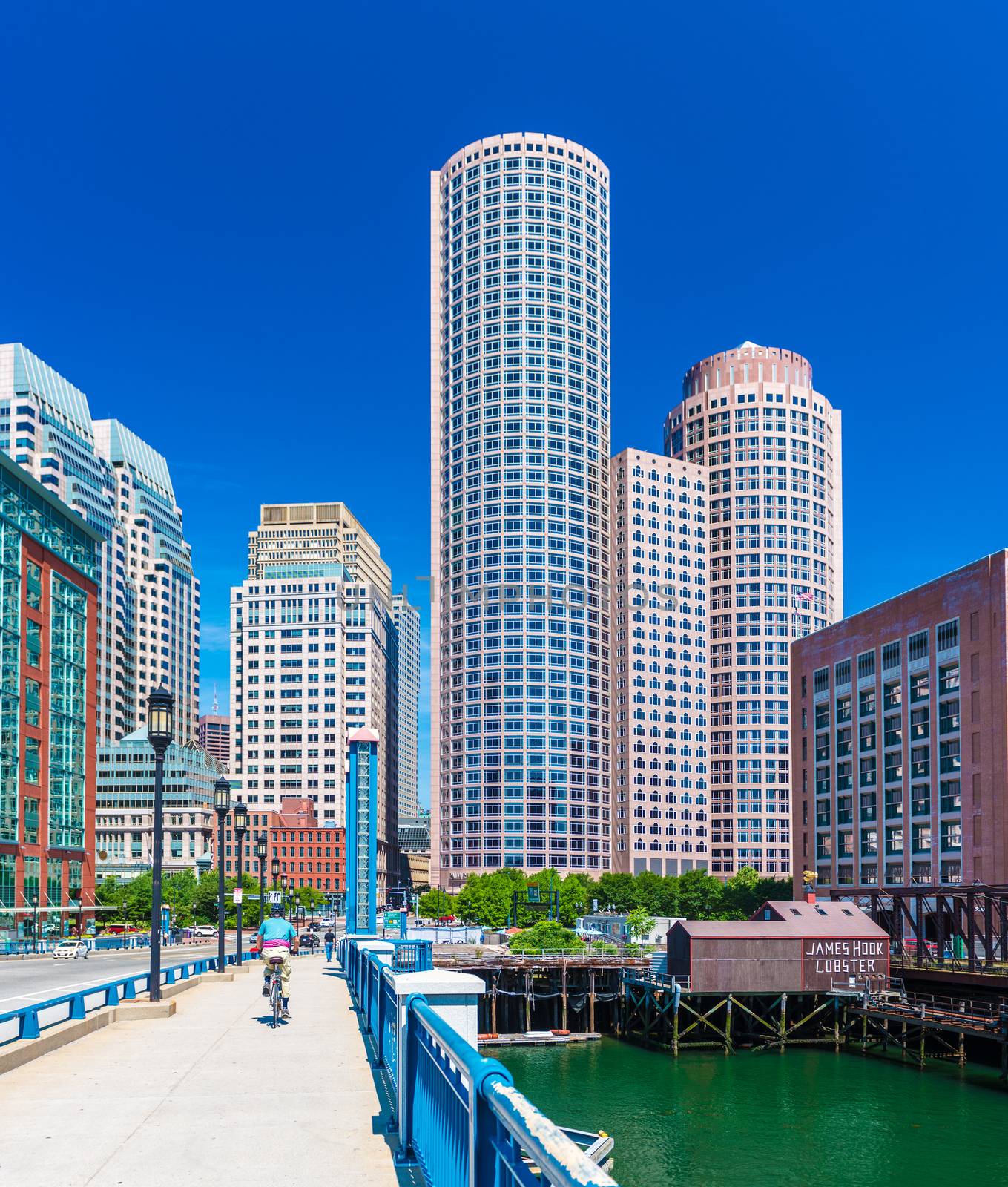 Boston, MA - June 2016, USA: Man cycling on Evelyn Moakley Bridge towards Boston downtown in sunny summer day