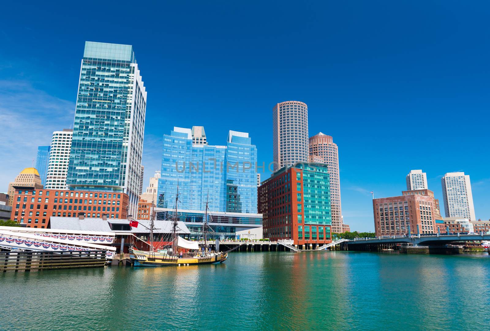 Boston - June 2016, MA, USA: Boston skyline, old historic ship in Tea Party museum and modern buildings in downtown reflected in the water of Boston harbor