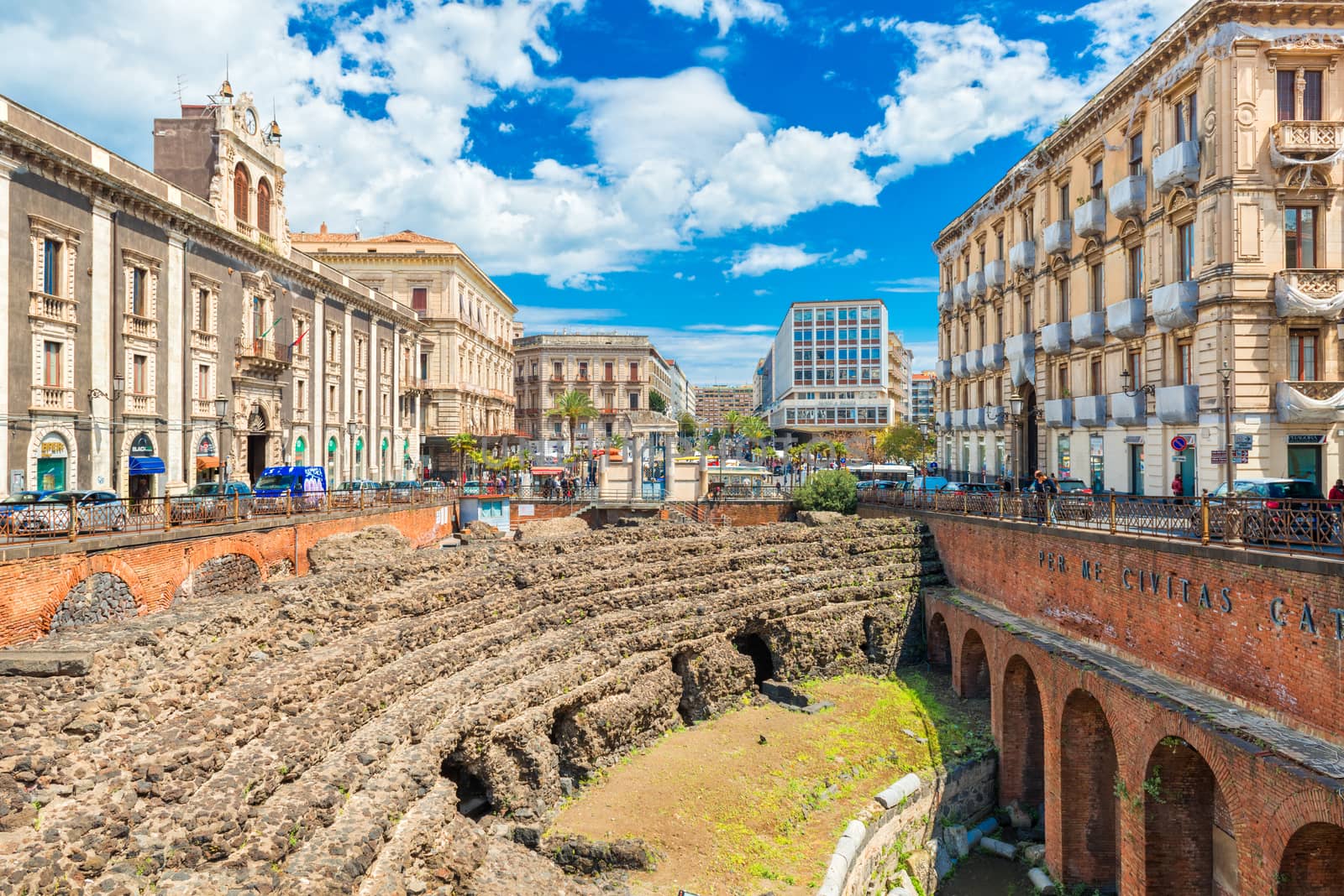 Catania - April 2019, Sicily, Italy: The Roman Amphitheater in Catania, ruins of an ancient theater next to the Palace of Tezzano (Palazzo Tezzano)