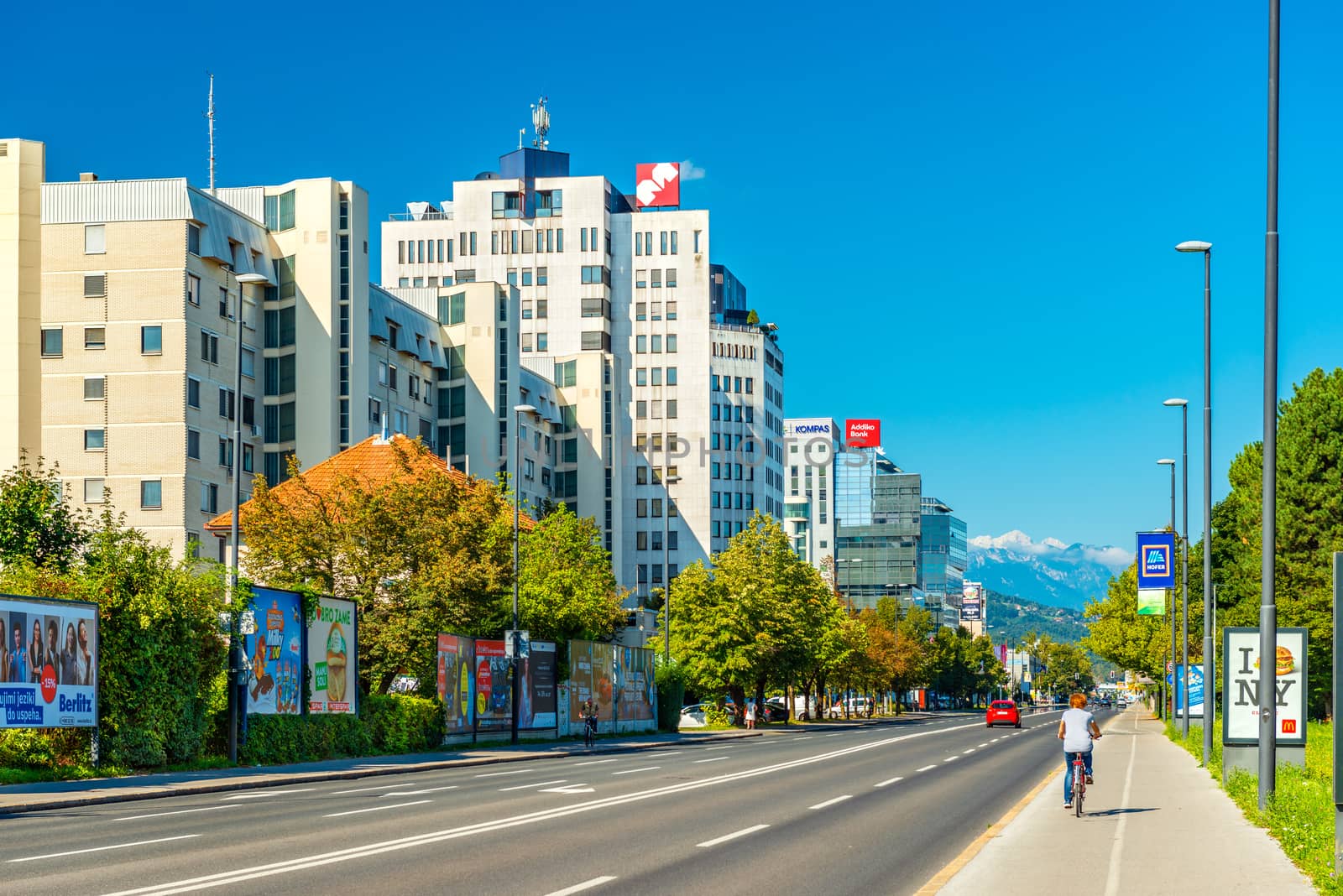 Ljubljana - September 2019, Slovenia: Modern residential and office buildings on one of the principal streets in the city "Dunajska Cesta", clear blue sky and the beautiful Alps in the background