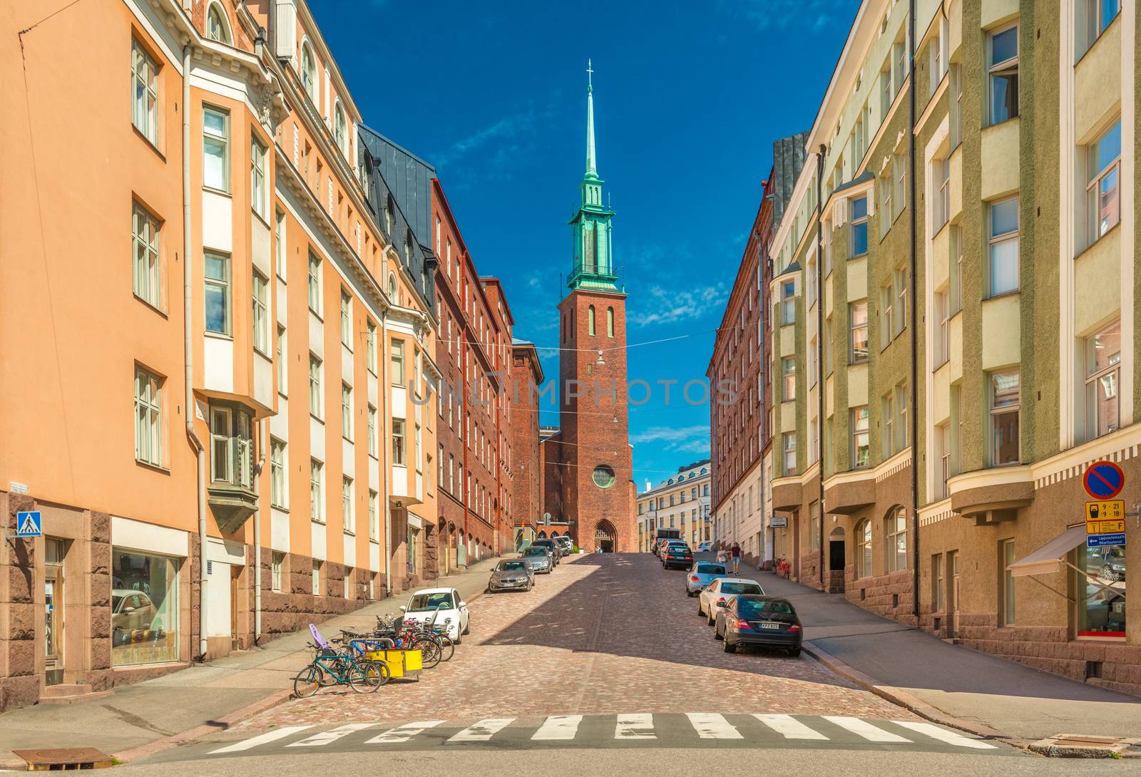 Helsinki - June 2019, Finland: A street with the traditional architecture and the Swedish Church (Kristuskyrkan) in the neo-gothic style