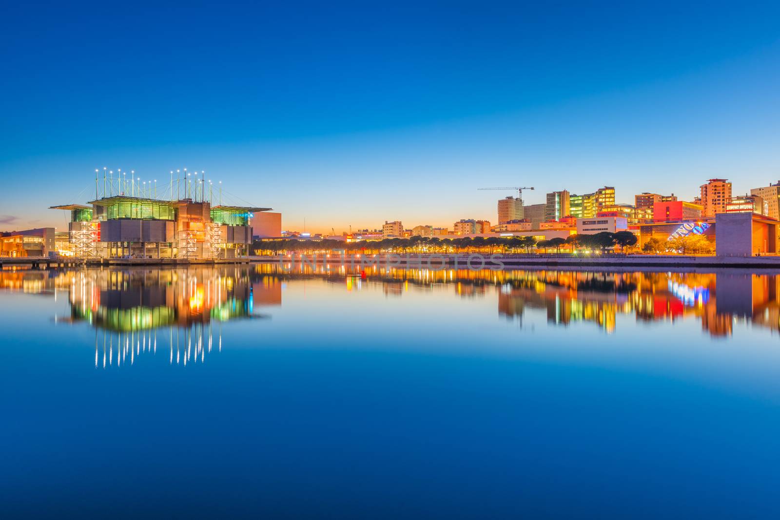 Lisbon - February 2019, Portugal: Evening cityscape mirrored in the water. View of The Park of Nations (Parque das Nações) and Oceanarium of Lisbon (Oceanário de Lisboa)