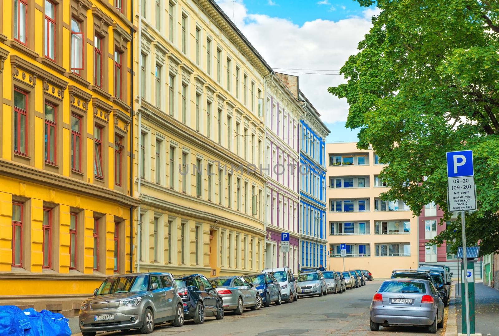 Oslo - June 2019, Norway: A street of Oslo with colorful historical architecture and cars parked along the street