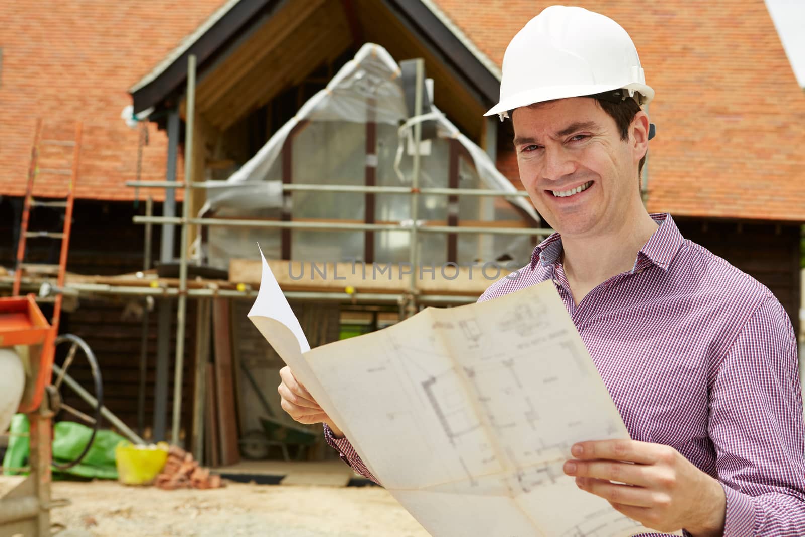 Portrait Of Architect On Building Site Looking At House Plans by HWS